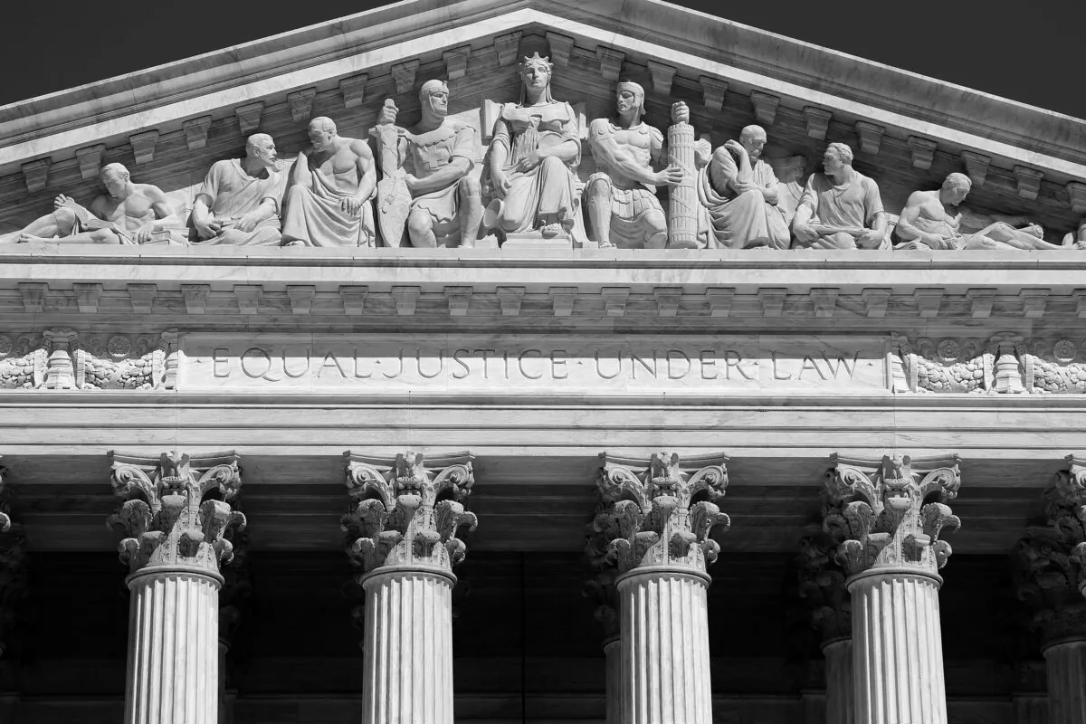 A pediment on the U.S. Supreme Court building with sculptural reliefs pertaining to law and order. Below the reliefs is the inscription "Equal justice under law." (The History Press)