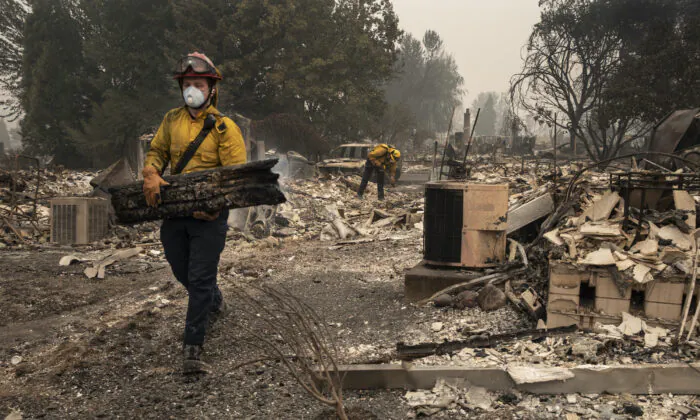 Jackson County District 5 firefighter Captain Aaron Bustard works on a smoldering fire in a burned neighborhood in Talent, Ore., Friday, Sept. 11, 2020, as destructive wildfires devastate the region. (Paula Bronstein/AP Photo)