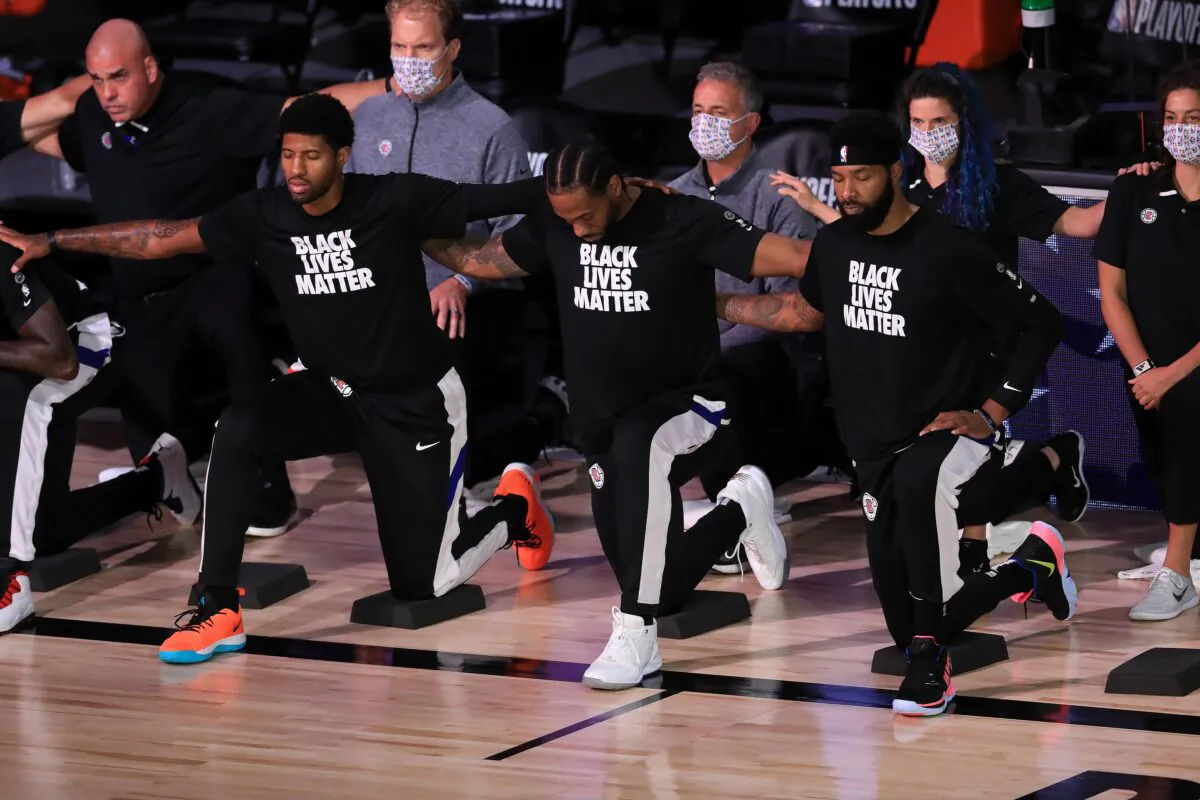 Los Angeles Clippers players and staff kneel during the national anthem before their game against the Denver Nuggets at the ESPN Wide World Of Sports Complex in Lake Buena Vista, Fla., on Sept. 11, 2020. (Michael Reaves/Getty Images)
