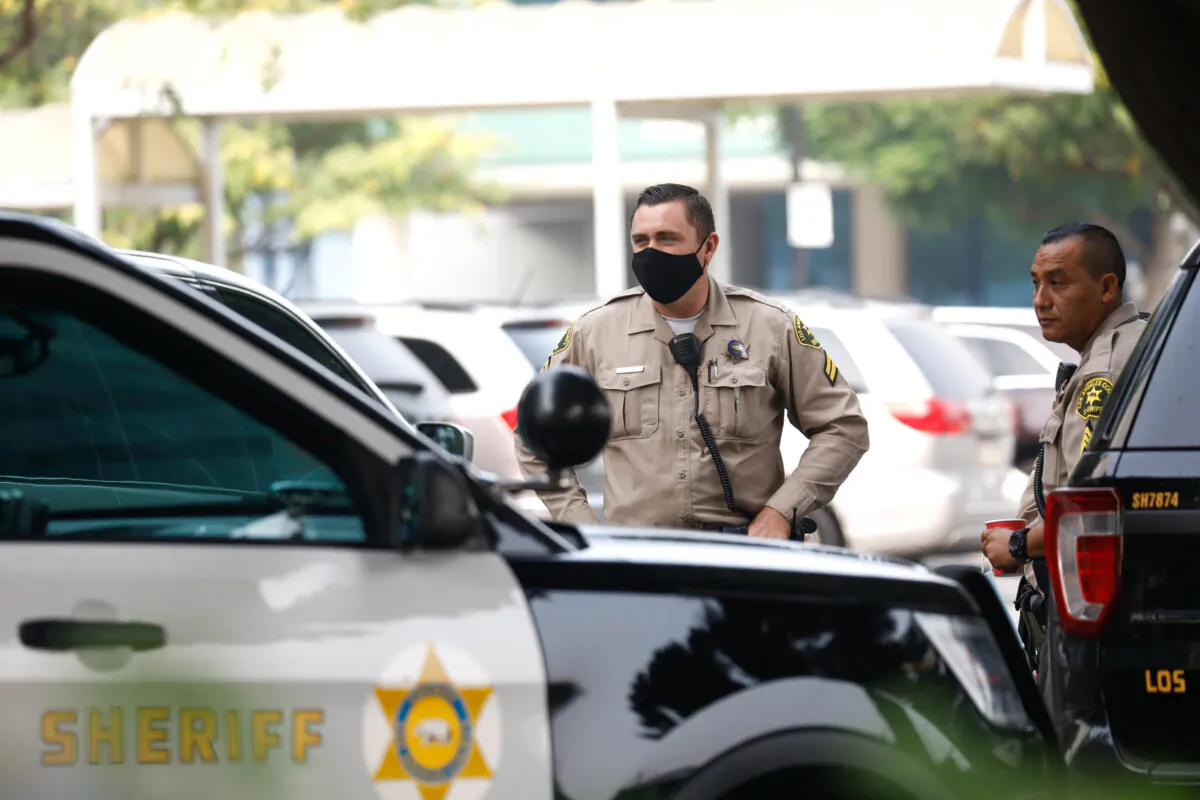 Los Angeles County Sheriffs Department deputies stand near their vehicles in Lynwood, Calif. in a file photo. (Patrick T. Fallon/Reuters)