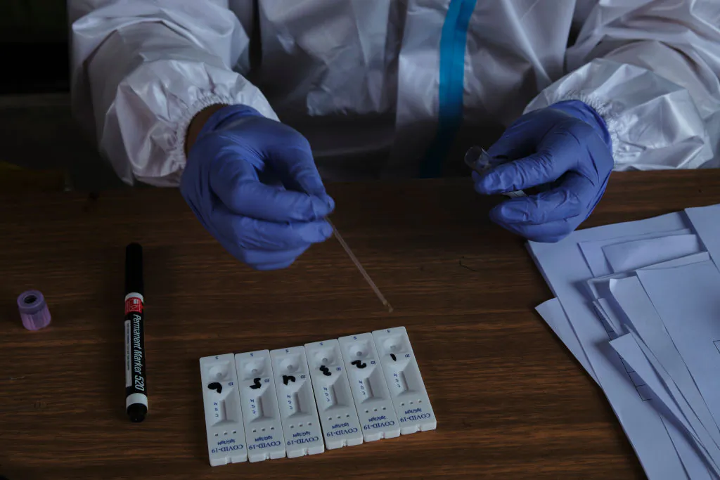An Indonesian nurse performing a COVID-19 rapid test at a football stadium that is being converted into a hospital for Covid-19 patients in Jarkarta, Indonesia on September 11, 2020. (Ed Wray/Getty Images)