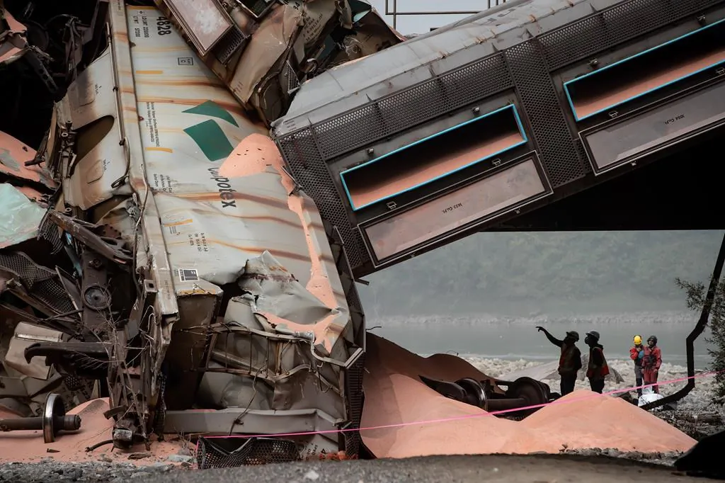 Officials look over the scene where a train carrying potash derailed near Hope, B.C, on Sept. 14, 2020. (The Canadian Press/Darryl Dyck)