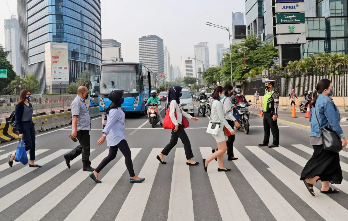 People wearing masks as a precaution against the new coronavirus outbreak, walk on a pedestrian crossing at the main business district in Jakarta, Indonesia, on Sept. 14, 2020. (Tatan Syuflana/AP Photo)