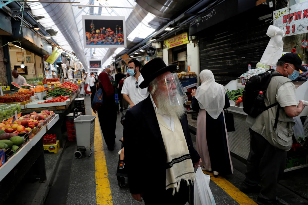 People wear face masks as they shop in a main market in Jerusalem, Israel, on July 16, 2020. (Ronen Zvulun/Reuters)