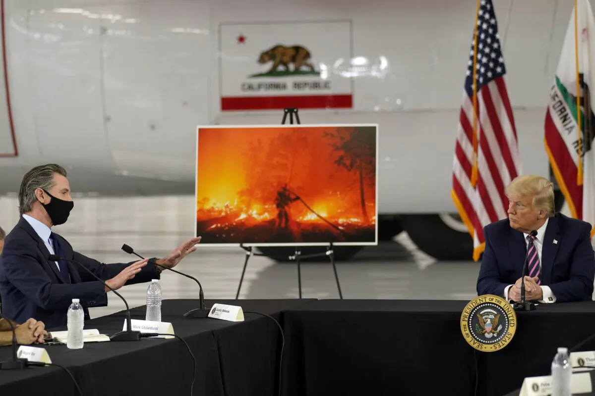 President Donald Trump listens as California Gov. Gavin Newsom speaks during a briefing at Sacramento McClellan Airport in McClellan Park, Calif., on Sept. 14, 2020. (Andrew Harnik/AP Photo)