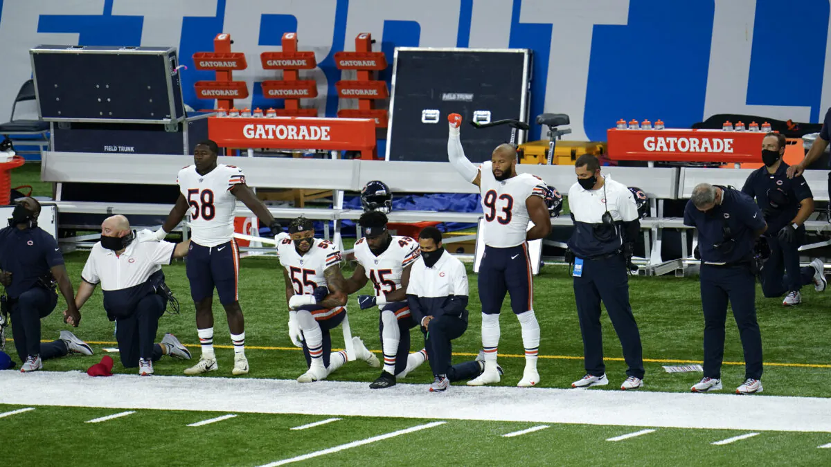 Chicago Bears Roquan Smith (58), Josh Woods (55), Joel Iyiegbuniwe (45) and James Vaughters (93) kneel during the national anthem before an NFL football game against the Detroit Lions in Detroit, Mich., Sept. 13, 2020. (Paul Sancya/AP Photo)