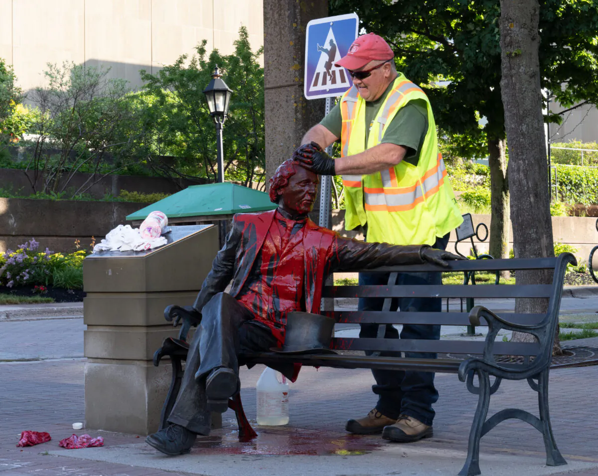 Ivan Mcguigan, of the Charlottetown Public Works department, cleans Sir John A Macdonald statue in Charlottetown after red paint was dumped on the statue on Friday June 19, 2020.The canadian Press/John Morris