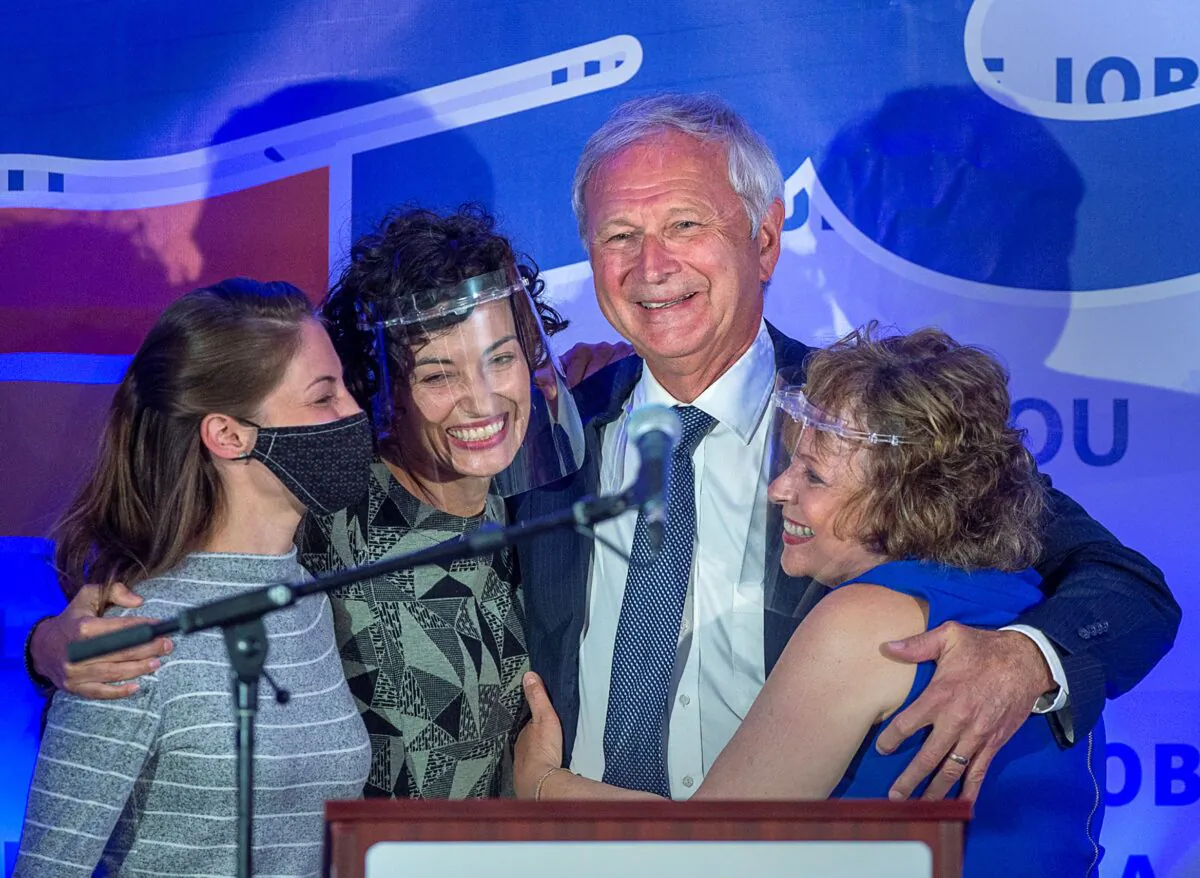 Premier Blaine Higgs embraces his wife and daughters after winning the New Brunswick provincial election, in Quispamsis, N.B., on Sept. 14, 2020. (The Canadian Press/Andrew Vaughan)