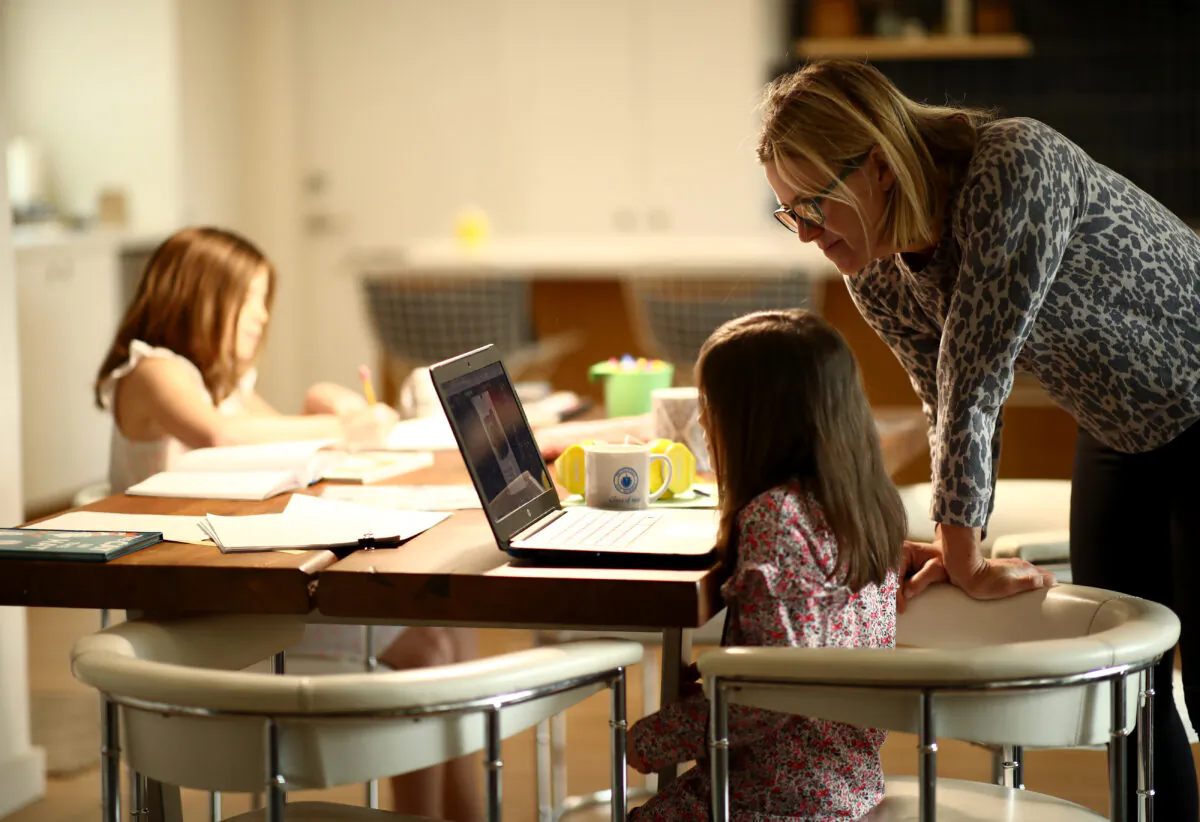 Daisley Kramer helps her kindergarten daughter, Meg, with schoolwork at home in San Anselmo, Calif., on March 18, 2020. (Ezra Shaw/Getty Images)