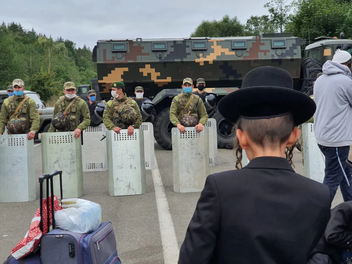 Jewish pilgrims, who plan to enter Ukraine from the territory of Belarus, gather in front of Ukrainian service members near Novi Yarylovychi crossing point in Chernihiv Region, Ukraine, on Sept. 15, 2020. (Breslev live/Handout via Reuters)