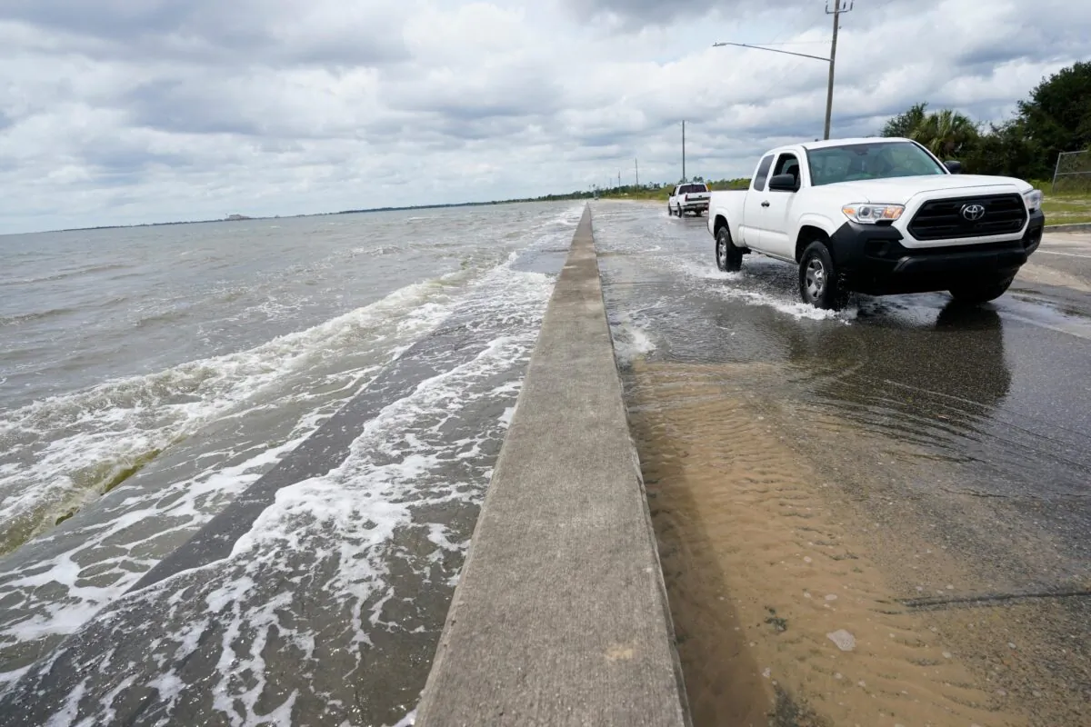 Waters from the Gulf of Mexico pour onto a local road, in Waveland, Miss., on Sept. 14, 2020. (Gerald Herbrt/AP Photo)