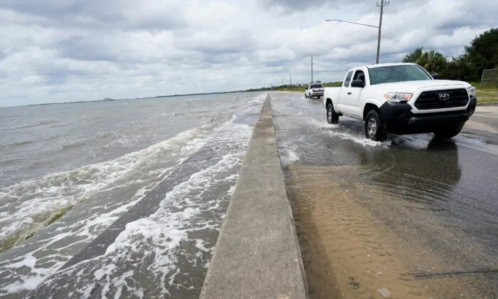 Waters from the Gulf of Mexico pour onto a local road, in Waveland, Miss., on Sept. 14, 2020. (Gerald Herbrt/AP Photo)