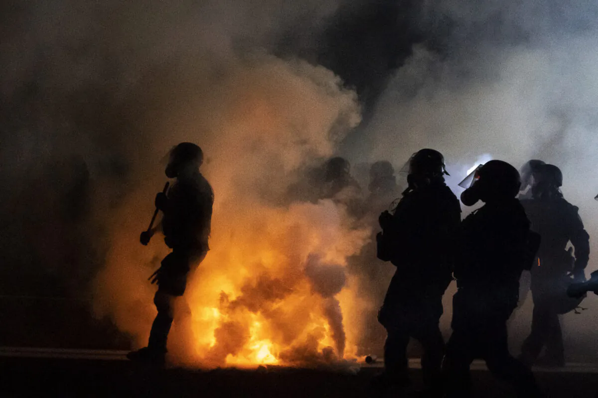 Oregon State Troopers and Portland police advance through tear gas while confronting rioters in Portland, Ore., on Sept. 5, 2020. (Nathan Howard/Getty Images)