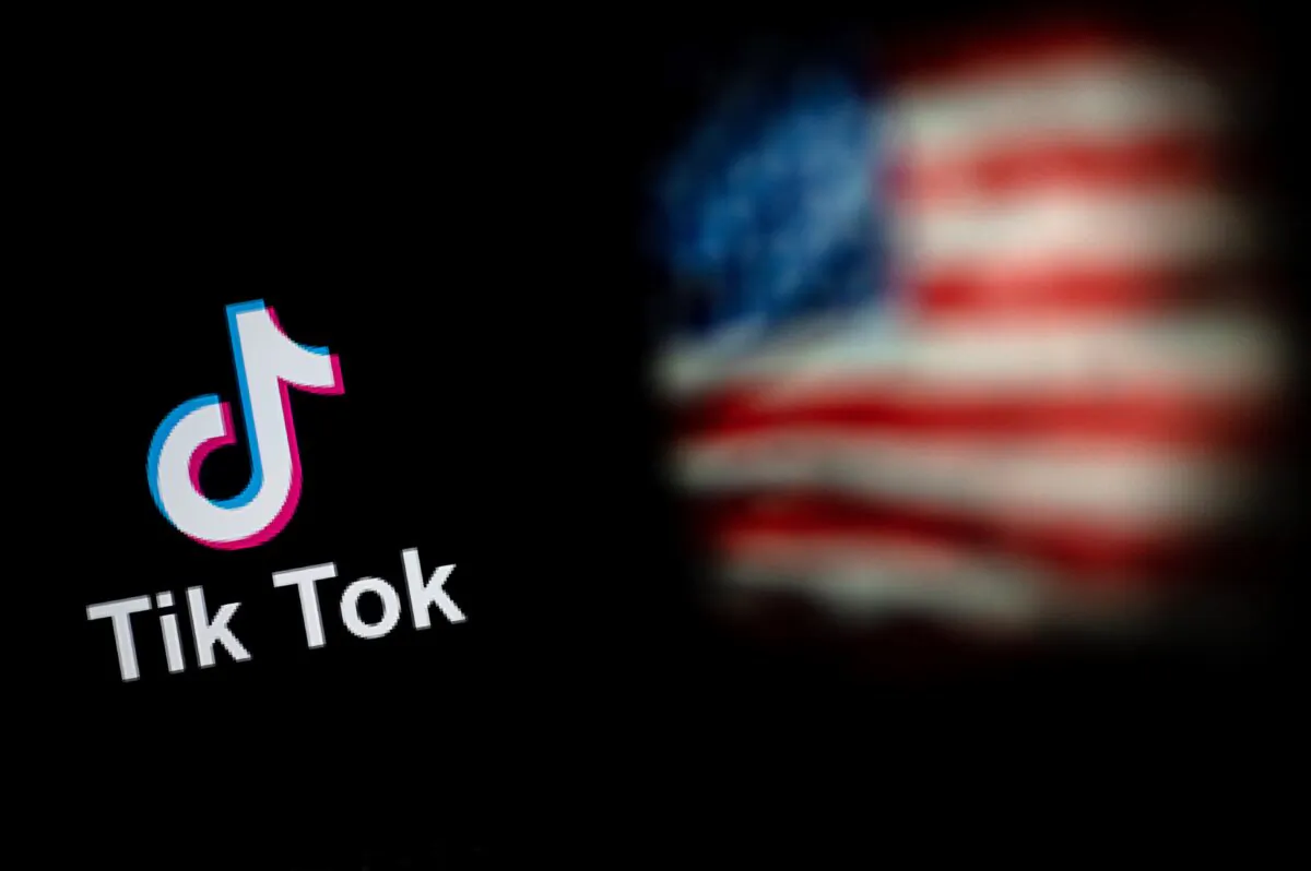 The logo of the social network application TikTok (L) and a U.S. flag (R) shown on the screens of two laptops in Beijing, China, on Sept. 14, 2020. (Nicolas Asfouri/AFP via Getty Images)