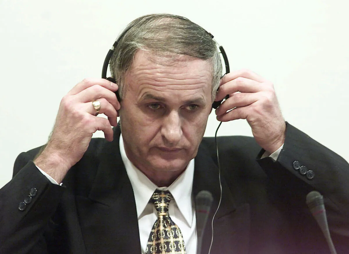 Bosnian Serb Gen. Radislav Krstic puts on headphones as he takes his seat in the courtroom in The Hague, Netherlands, on Aug. 2, 2001. (Ed Oudenaarden/Pool Photo via AP, File)