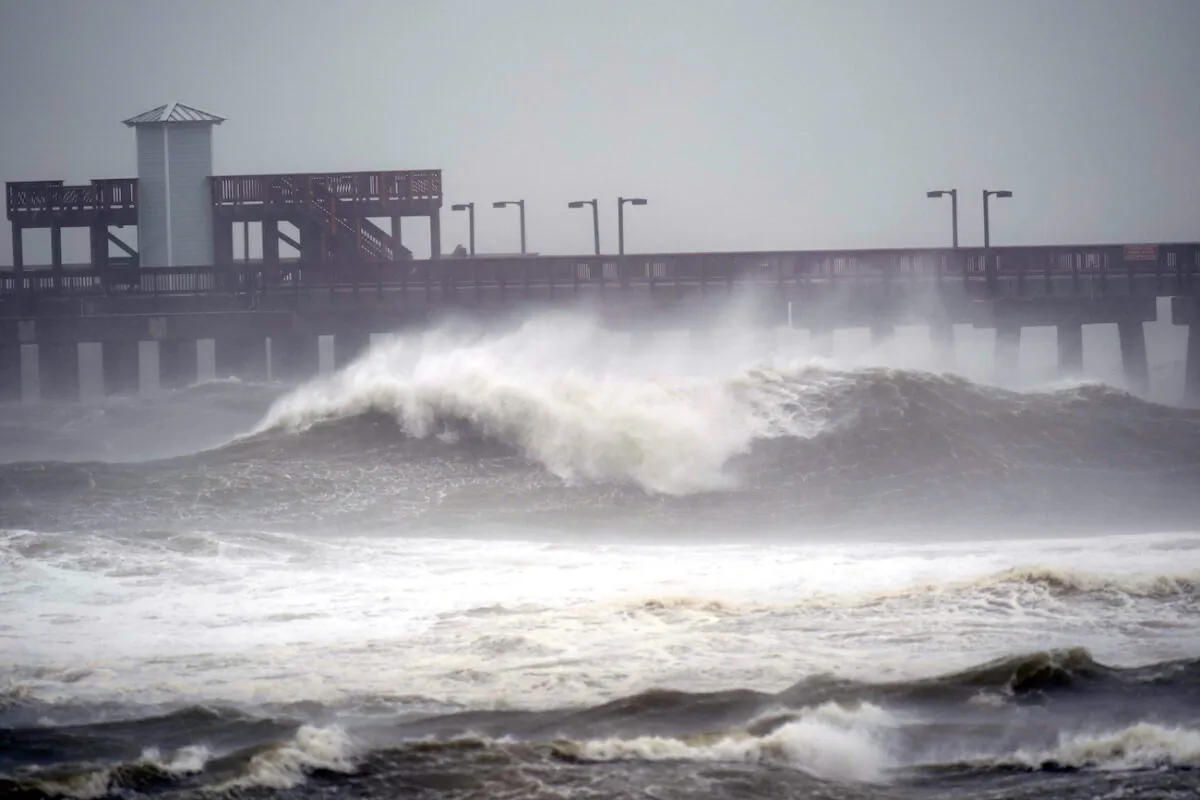 Waves crash near a pier, at Gulf State Park, in Gulf Shores, Ala. on Sept. 15, 2020. (AP Photo/Gerald Herbrt)