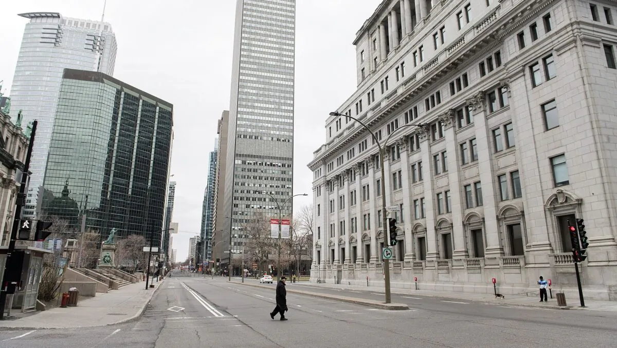 A man crosses a deserted street in downtown Montreal during the COVID-19 pandemic lockdown on April 5, 2020. (The Canadian Press/Graham Hughes)