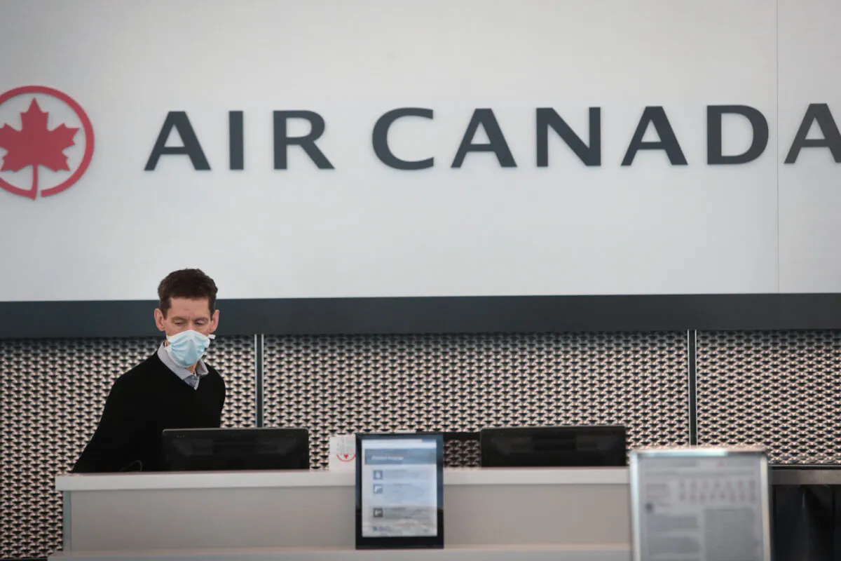 An Air Canada worker waits for travellers at a nearly-empty O'Hare International Airport in Chicago, Ill,. on April 2, 2020. (Scott Olson/Getty Images)
