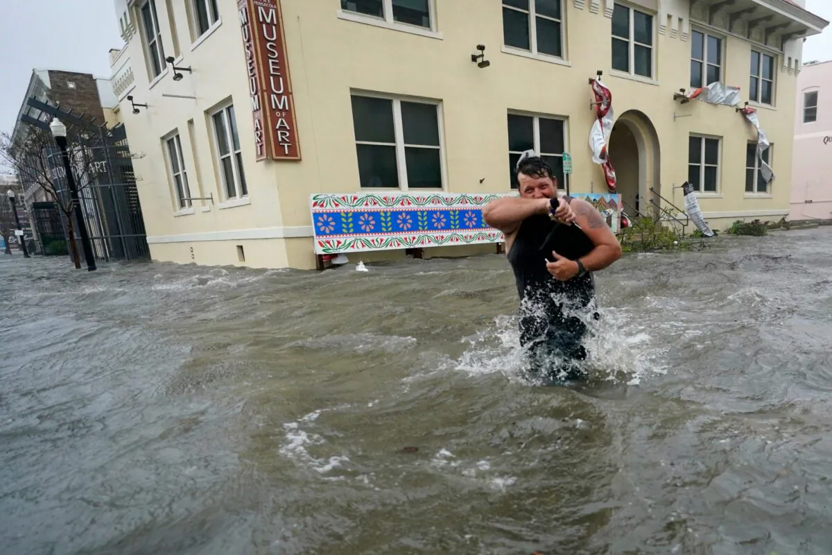 Trent Airhart wades through floodwaters, in downtown Pensacola, Fla., on Sept. 16, 2020. (Gerald Herbert/AP Photo)
