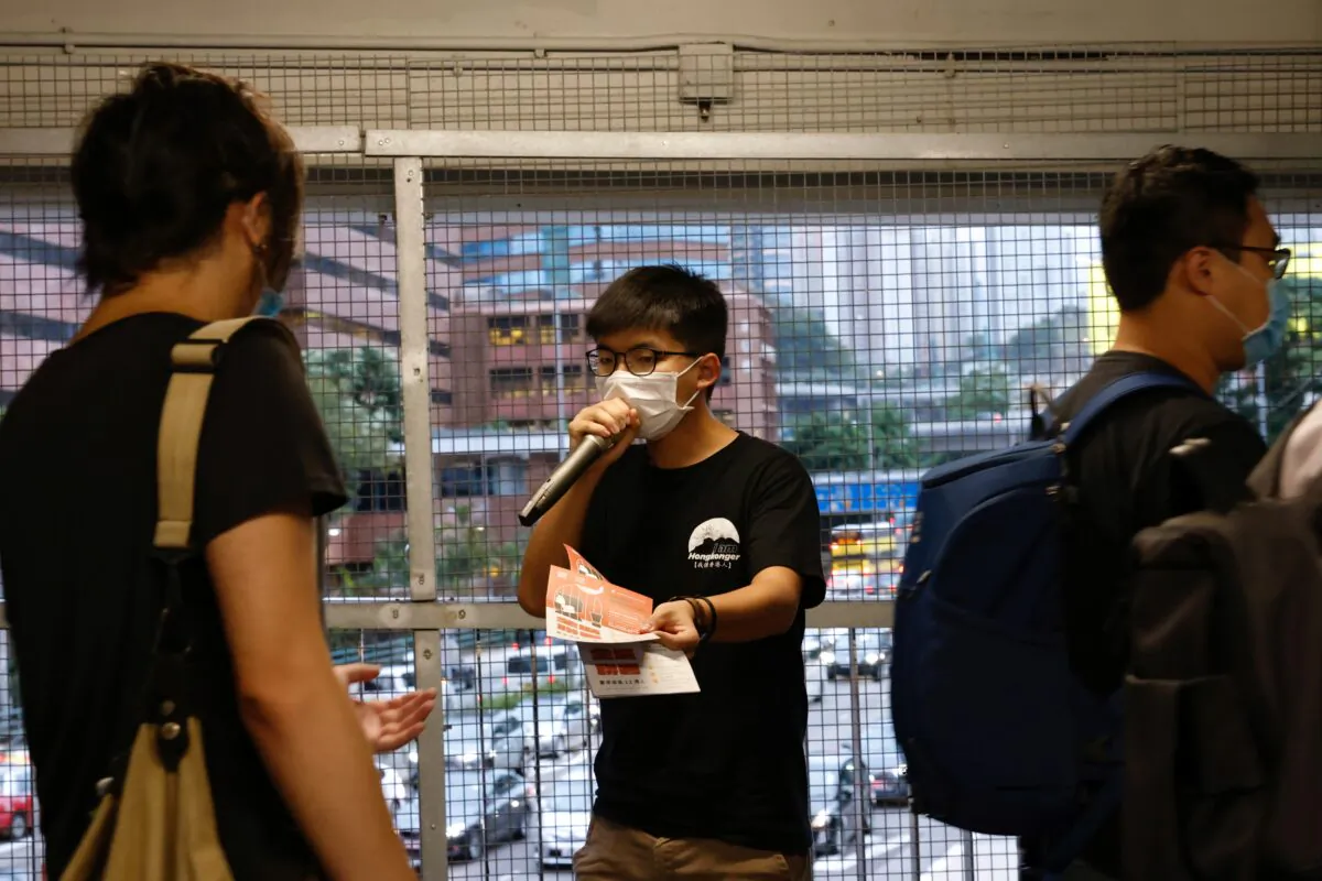 Pro-democracy activist Joshua Wong distributes leaflets encouraging people to send postcards to twelve Hong Kong residents being held in the Chinese mainland after attempting to flee to Taiwan, in Hong Kong, China, on Sept. 18, 2020. (Tyrone Siu/Reuters)