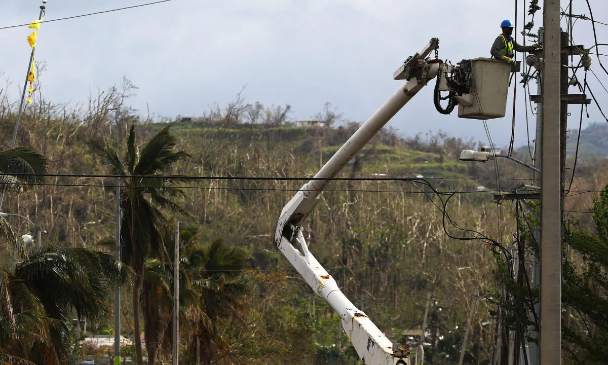 A worker repairs power lines about two weeks after Hurricane Maria in San Isidro, Puerto Rico. Puerto Rico, on Oct. 5, 2017. (Mario Tama/Getty Images)