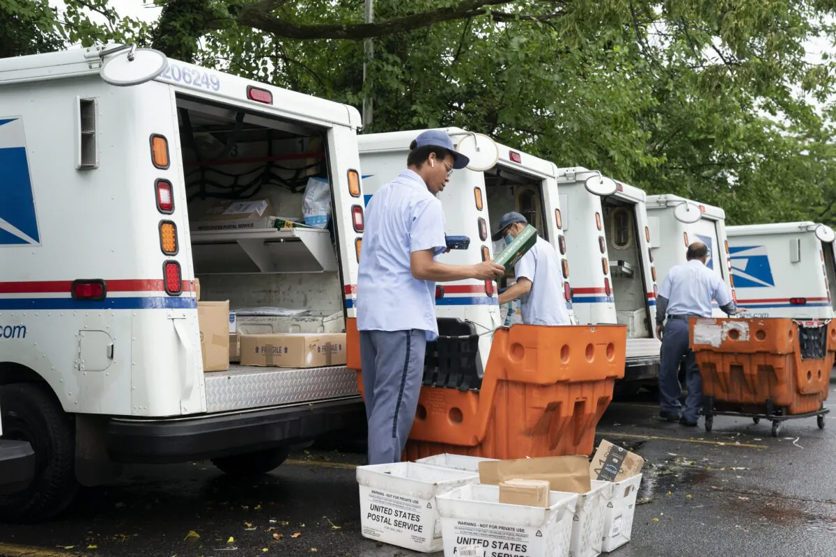 Letter carriers load mail trucks for deliveries at a U.S. Postal Service facility in McLean, Va., July 31, 2020. (J. Scott Applewhite/AP Photo)