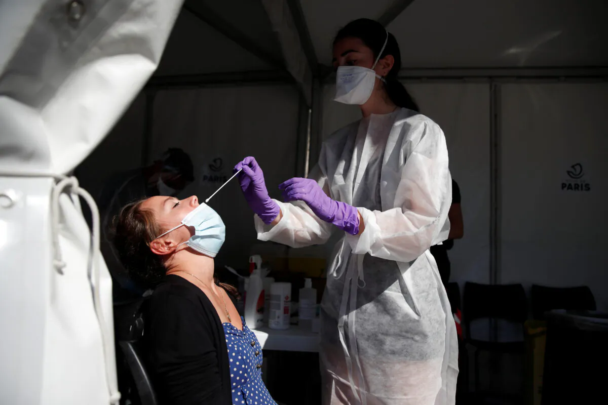 A health worker prepares to administer a nasal swab to a patient at a COVID-19 testing site in Paris on Sept. 14, 2020. (Gonzalo Fuentes/Reuters)
