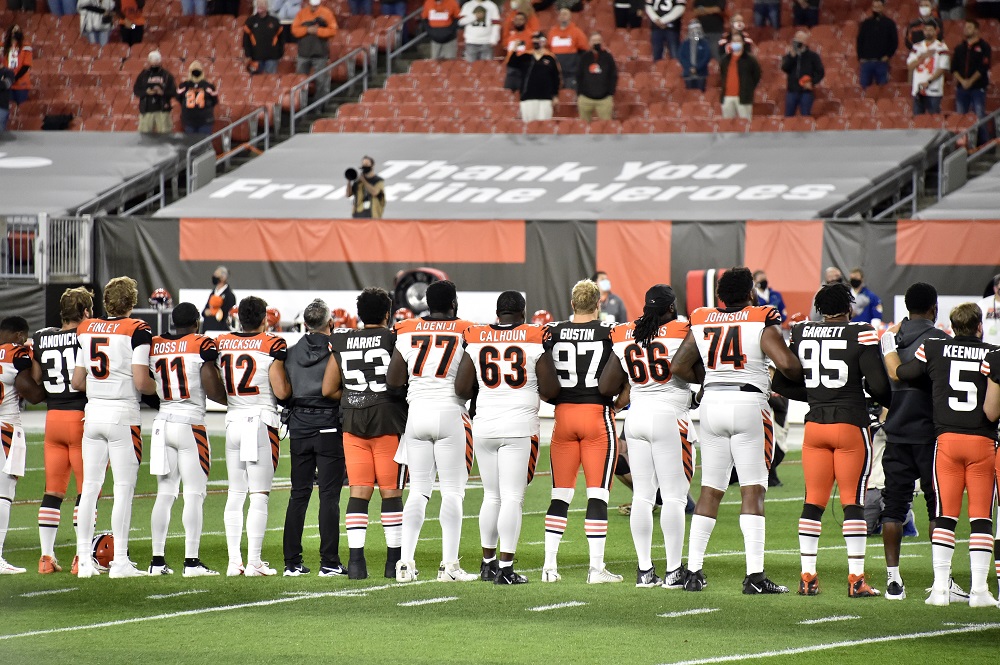 Players lock arms before the start of a game between the Cleveland Browns a...
