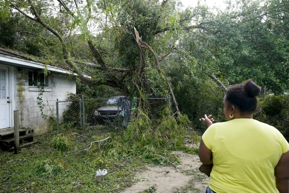 Seleka Souls looks over a neighbor's home that was damaged by Hurricane Sally on Sept. 18, 2020, in Pensacola, Fla. (AP Photo/Gerald Herbert)