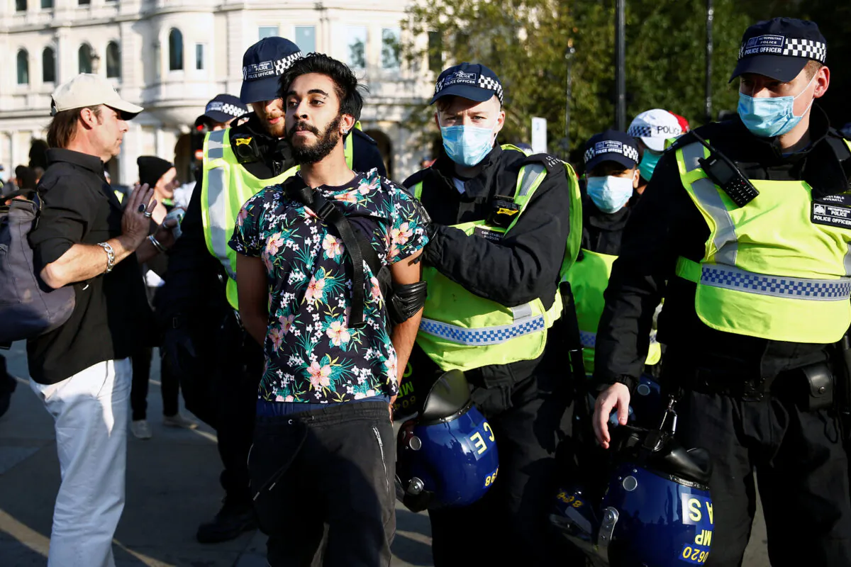 A man is detained during a demonstration in Trafalgar Square against the lockdown imposed by the government, in London, on Sept. 19, 2020. (Henry Nicholls/Reuters)