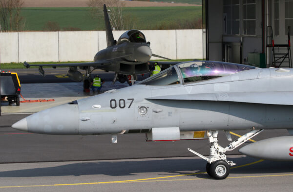 A Swiss Air Force F/A-18C Hornet passes in front of a Eurofighter Typhoon jet to replace the fighter jets of the Swiss Air Force