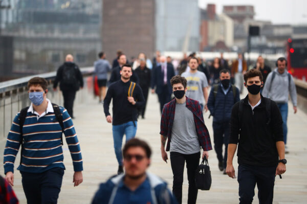 Commuters walk across London Bridge during the morning rush hour, amid an outbreak of the CCP virus in London