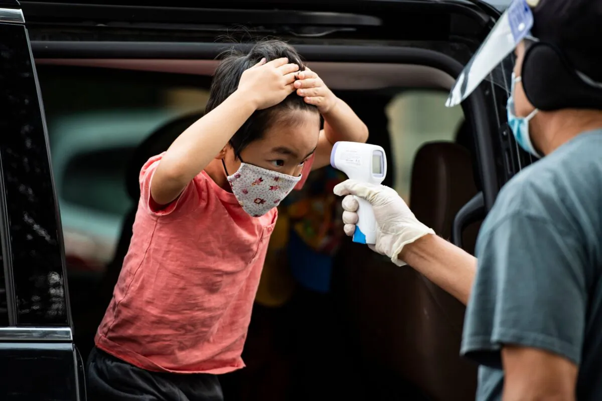 A student has his temperature taken as he arrives at STAR Eco Station Tutoring & Enrichment Center for remote school classes in Culver City, Calif., on Sept. 10, 2020. (Robyn Beck/AFP via Getty Images)