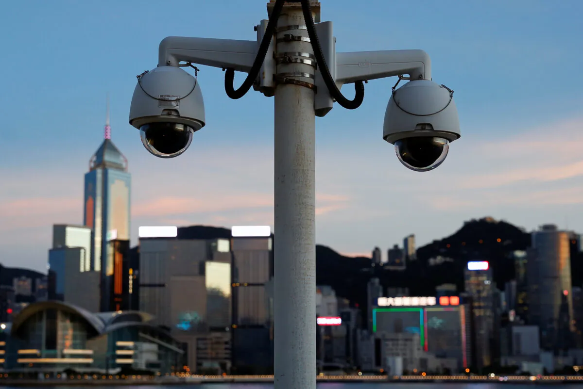 A pair of surveillance cameras along the Tsim Sha Tsui waterfront as skyline buildings stand across Victoria Harbor in Hong Kong, on July 28, 2020. (Tyrone Siu/Reuters)