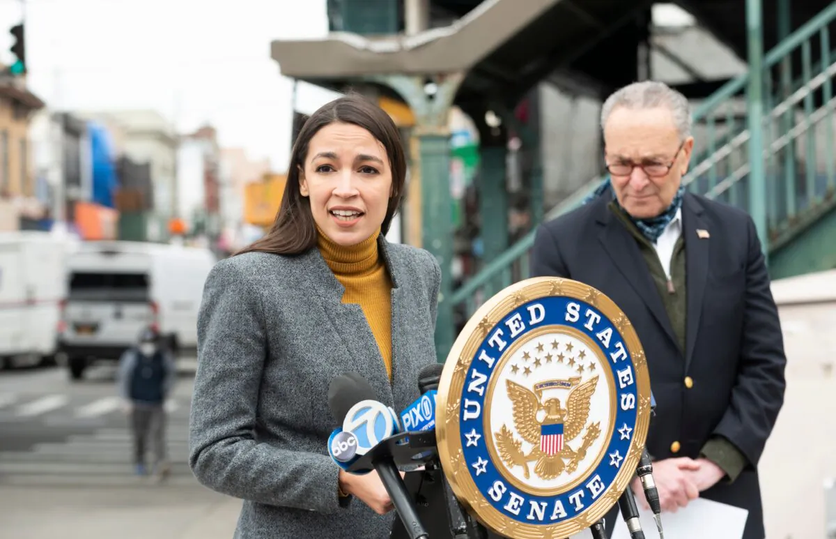 Rep. Alexandria Ocasio-Cortez (D-N.Y.) speaks as Senate Minority Leader Chuck Schumer (D-N.Y.) listens during a press conference in the Corona neighborhood of Queens in New York on April 14, 2020. (Johannes Eisele/AFP via Getty Images)