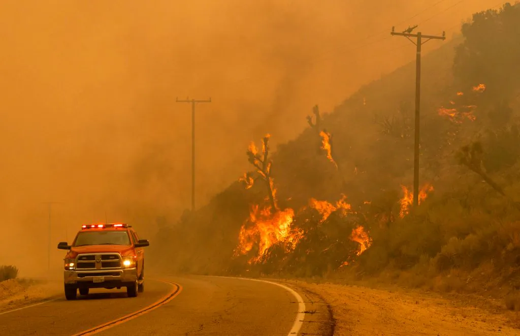 A firefighter drives past a burning hillside as the Bobcat Fire burns through Valyermo, Calif., on Sept. 18, 2020. (Kyle Grillot/AFP via Getty Images)