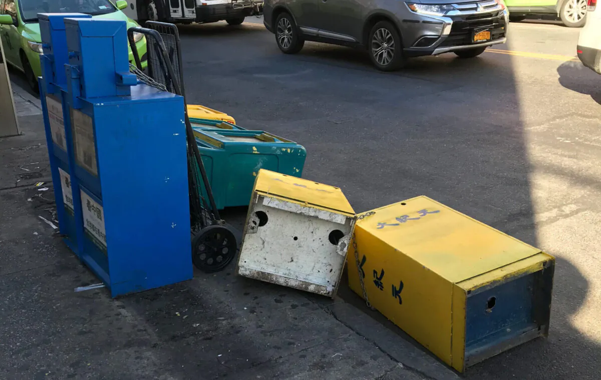 Newspaper boxes belonging to the Chinese-language Epoch Times toppled onto the streets of Flushing, New York City, in September 2020. (The Epoch Times)
