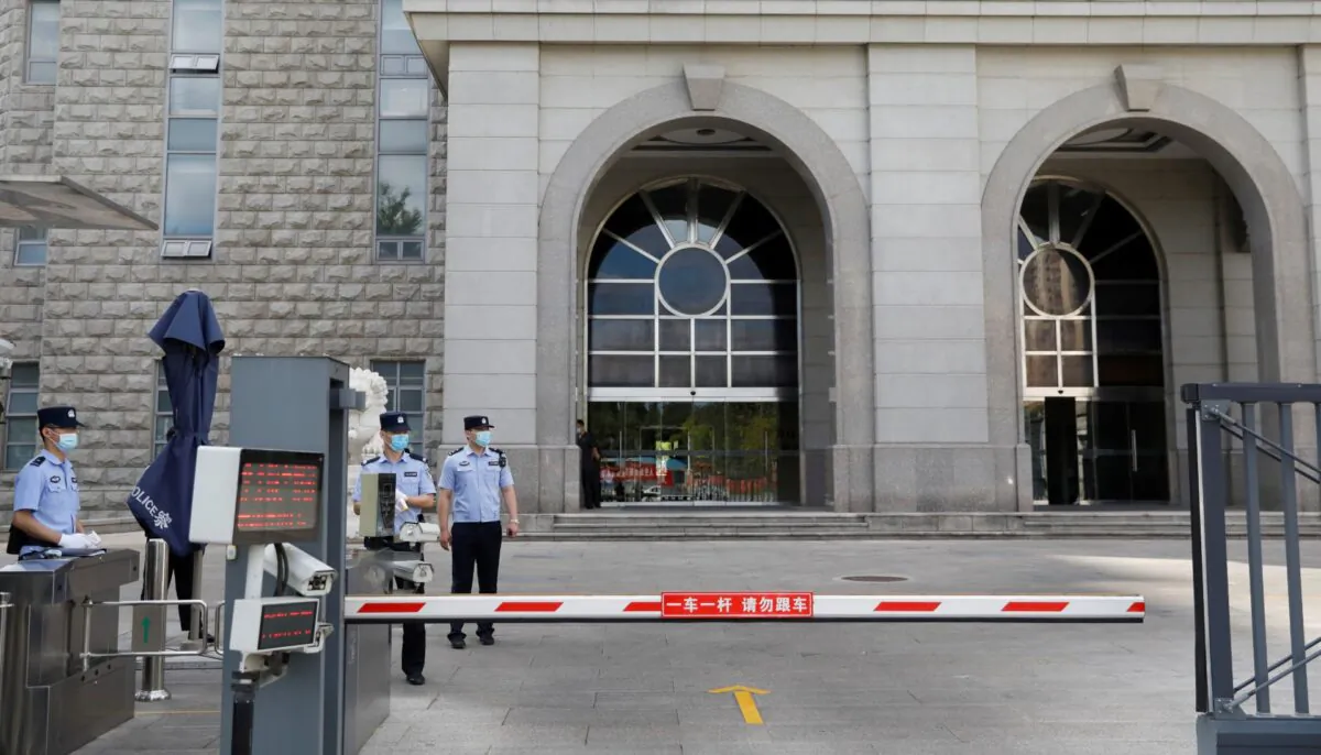 Police officers stand guard at an entrance to a court in Beijing, on Sept. 11, 2020. (Carlos Garcia Rawlins/File/Reuters)