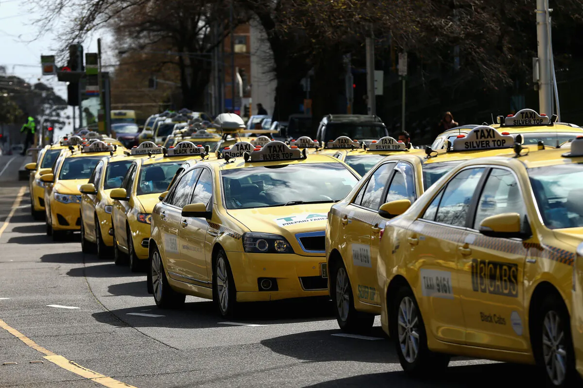 MELBOURNE, AUSTRALIA - SEPTEMBER 10: Taxi cars are lined up as protesters gather on September 10, 2015 in Melbourne, Australia. Tram drivers are striking for over a pay dispute between drivers and employer Yarra Trams, while taxi drivers are walking off the job in protest of the illegal rideshare service UberX. (Photo by Robert Prezioso/Getty Images)