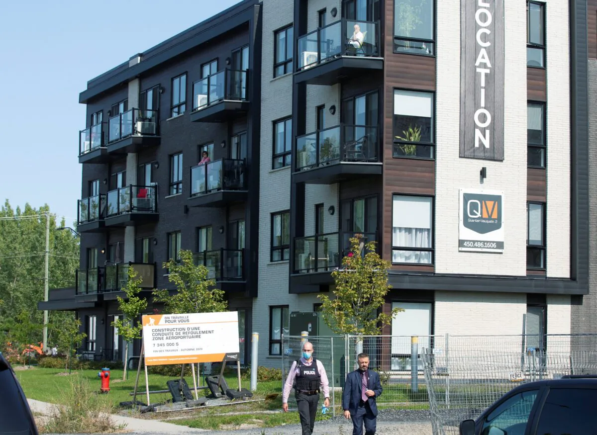 Police investigators walk past a condo building related to an investigation into the ricin-filled envelope sent to the White House, as the Royal Canadian Mounted Police (RCMP) Chemical, Biological, Radiological, Nuclear, Explosives team checks the area in Longueuil, Quebec, Canada on Sept. 21, 2020. (Christinne Muschi/Reuters)