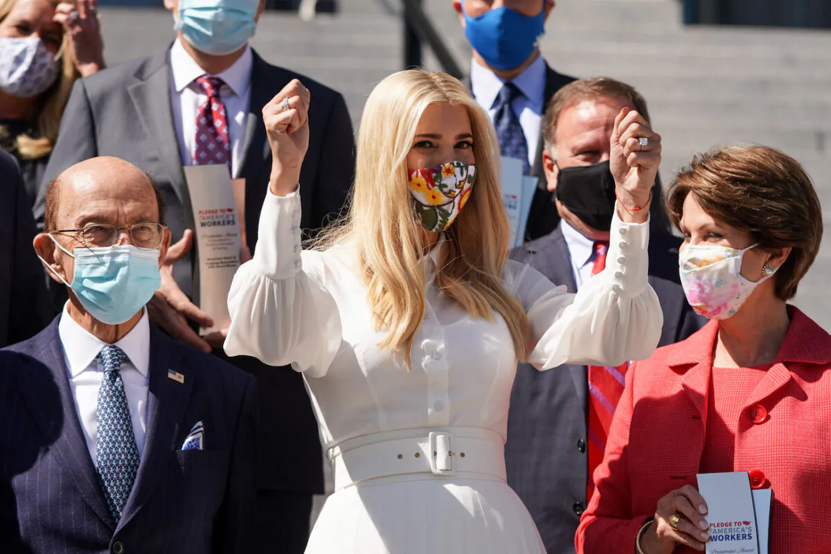 Senior White House Advisor Ivanka Trump raises her hands during a group photo with the winners of the Pledge To America's Workers Presidential Award in the Eisenhower Executive Office Building in Washington, on Sept. 23, 2020. (Joshua Roberts/Getty Images)