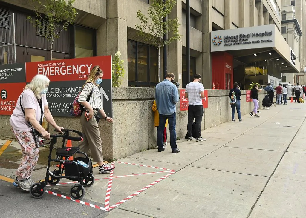 People wait in line for hours at a COVID assessment centre at Mount Sinai Hospital in Toronto, on Sept. 24, 2020. (The Canadian Press/Nathan Denette)