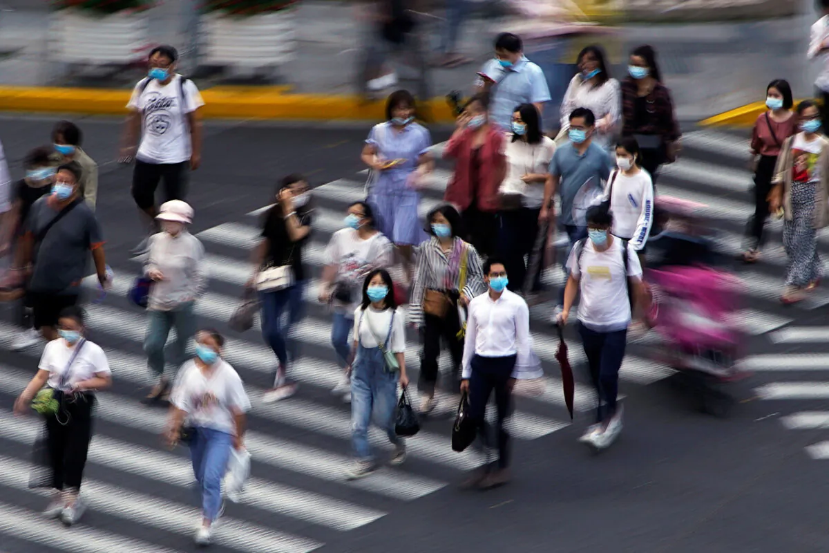 People wearing face masks walk on a street in Shanghai, China, on July 16, 2020. (Aly Song/Reuters)