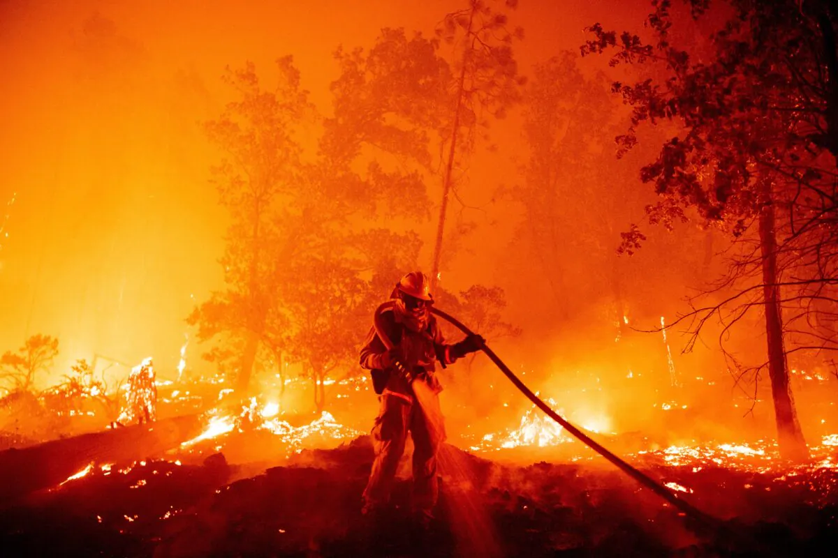 A firefighter douses flames as they push toward homes during the Creek fire in the Cascadel Woods area of unincorporated Madera County, Calif., on Sept. 7, 2020. (Josh Edelson/AFP via Getty Images)