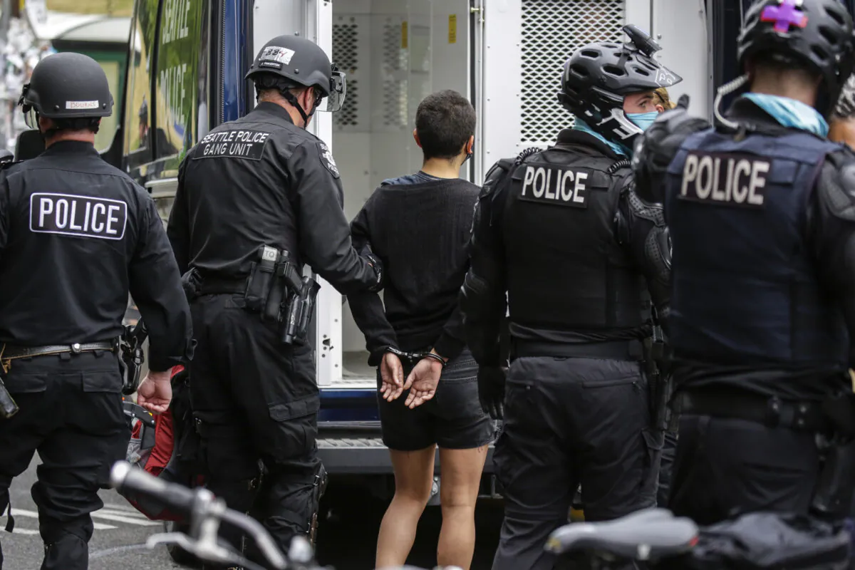Seattle Police arrest a woman after demonstrators blocked the intersection of East Pine Street and 11th Avenue following the clearing of the Capitol Hill Occupied Protest (CHOP) by police in Seattle, Wash. on July 1, 2020. (Jason Redmond/AFP via Getty Images)