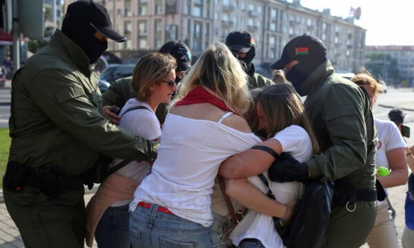Belarusian law enforcement officers block women during an opposition rally