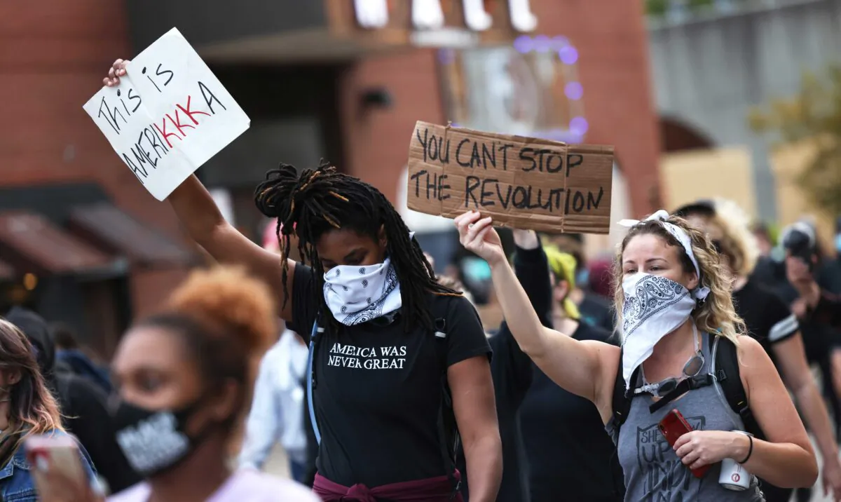 Demonstrators hold signs as they march in Louisville, Ky., on Sept. 24, 2020. (Michael M. Santiago/Getty Images)