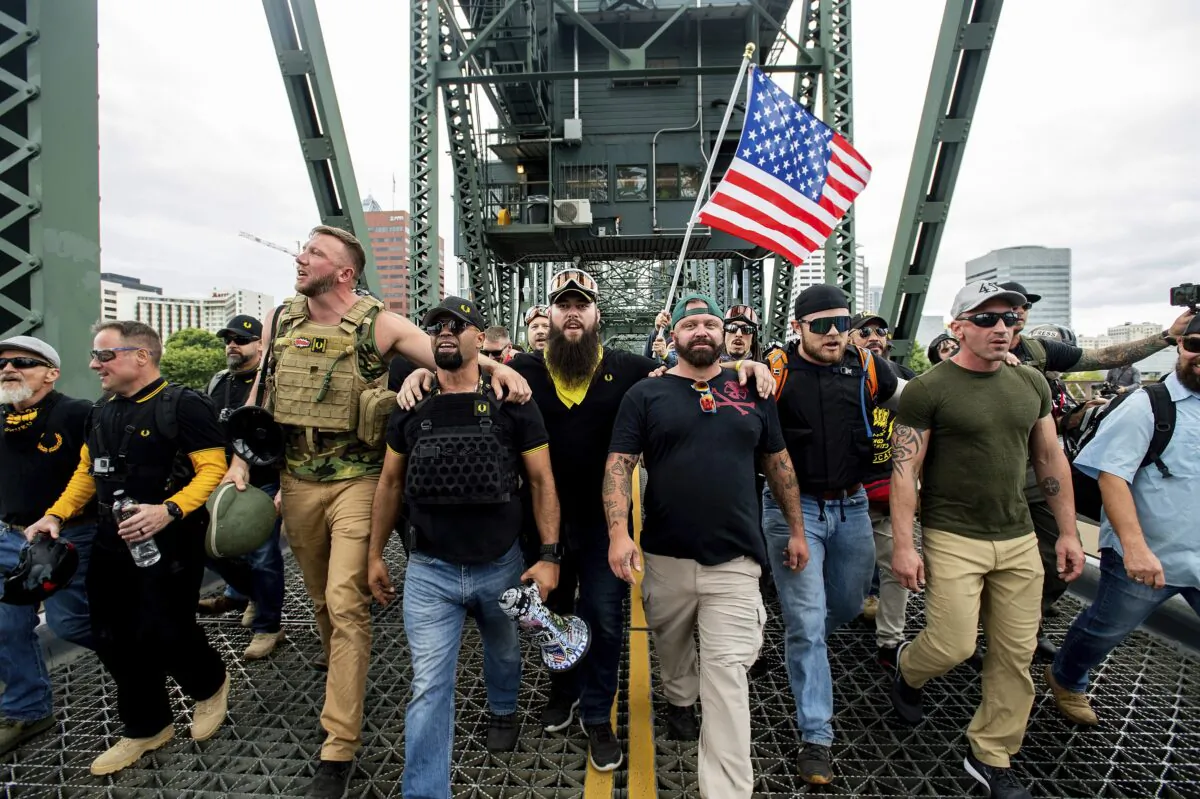 Members of the Proud Boys and Chairman Enrique Tarrio, holding a megaphone, along with other right-wing demonstrators, march across the Hawthorne Bridge during a rally in Portland, Ore., on Aug. 17, 2019. (Noah Berger/AP Photo)