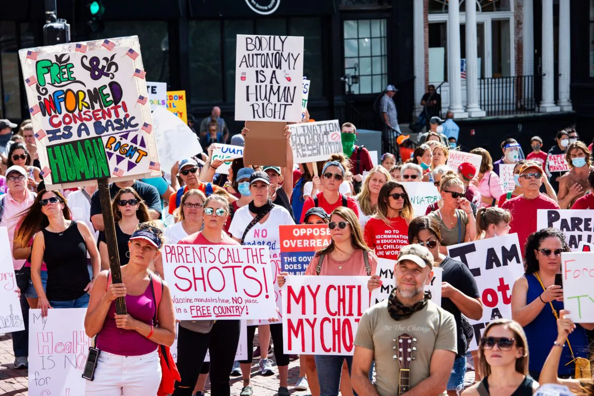 Hundreds of people of mixed political views, religions, and cultures protest a mandate from the Massachusetts Governor requiring all children, age K-12, to receive an influenza (flu) vaccine/shot to attend school for the 2020/2021 year outside the Massachusetts State House in Boston on Aug. 30, 2020. (Joseph Prezioso/AFP via Getty Images)
