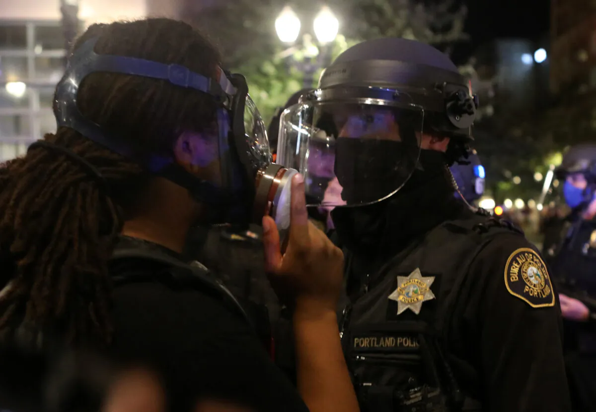 A law enforcement officer orders a demonstrator to move, in Portland, Ore., on Sept. 27, 2020. (Jim Urquhart/Reuters)